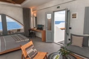 Un dormitorio con una cama y vista al mar. en Almyra Oia Suites, en Oia 37 fotos más