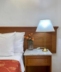 a lamp on a night stand next to a bed at Astoria Hotel in Buenos Aires