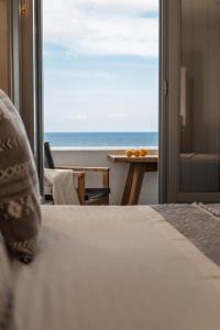 a bedroom with a bed and a view of the ocean at Almyra Oia Suites in Oia