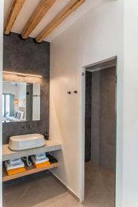 a bathroom with a sink and a mirror at Almyra Oia Suites in Oia