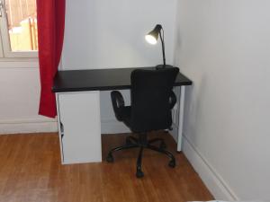 un bureau avec une chaise et une lampe. dans l'établissement Appart-Hotel T1 Lyon8 proche hopitaux, à Lyon