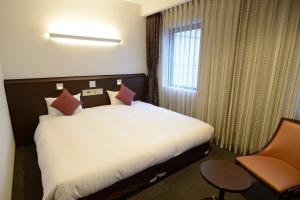 Una cama o camas en una habitación de Natural Hot Spring Midosuji Hotel