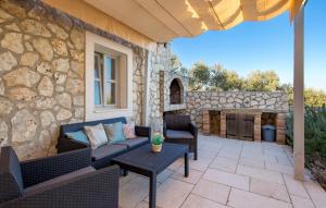 a patio with couches and a stone wall at Holiday Home Ruby in Sveti Jakov