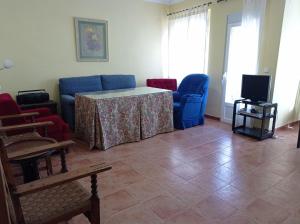 sala de estar con mesa, sillas y TV en EL RINCÓN DE BLASA, en Cazorla