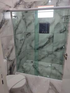 a bathroom with a toilet and a glass shower at Hotel Dolce Dulce in Olímpia