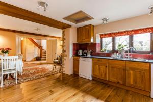 a kitchen with wooden cabinets and a dining room at The Stables in Chipping Campden