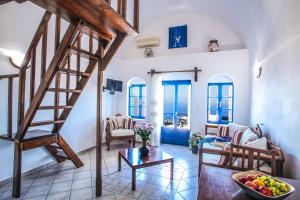 a living room with a staircase and a table at Pergeri Apartments in Imerovigli