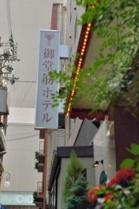 un grupo de señales en el lateral de un edificio en Natural Hot Spring Midosuji Hotel, en Osaka