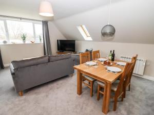 a living room with a table and a couch at Tree Tops in Witney