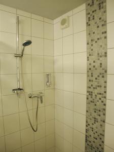 a shower in a bathroom with white tiles at Ferienwohnung Pusteblume in Cochem