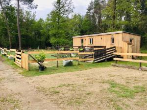 a wooden cabin in a field with a fence at Le Perchoir in Châtenoy