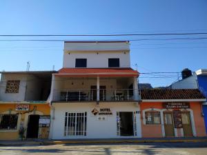 a white building with a balcony on top of it at HOTEL ANTHURIUM in Jalcomulco