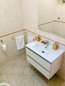 La salle de bains est pourvue d'un lavabo blanc et d'un miroir. dans l'établissement casaDAmare, à Pula