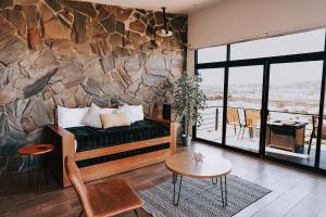 a living room with a couch and a stone wall at Siempre Valle Hotel Boutique in Valle de Guadalupe