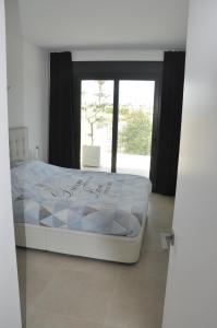 Una cama blanca en una habitación con ventana. en Casa del Mar Menor, en San Javier 16 fotos más