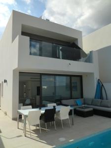 Una casa con una mesa y sillas al lado de una piscina. en Casa del Mar Menor, en San Javier