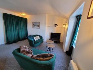 a living room with two green chairs and a couch at Sea view Penthouse flat 6 with fast WiFi and Free PARKING in Scarborough