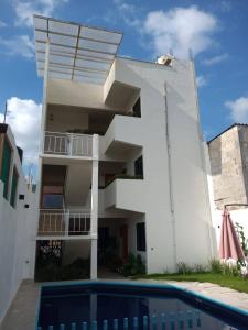 - un bâtiment blanc avec une piscine en face dans l'établissement HOTEL ANTHURIUM, à Jalcomulco