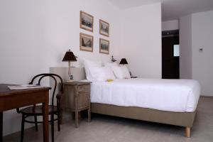 a bedroom with a white bed and a desk and a bed sidx sidx at Hôtel 96 in Marseille
