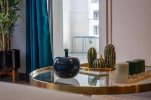 een glazen tafel met een vaas en cactussen erop bij Apartment with terrace and garage Classified 4 stars in Annecy