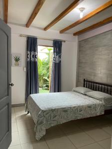 a bedroom with a bed and a window at Cabaña Riviera Pacific in Pedernales