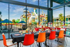 
a dining area with tables and chairs and umbrellas at Coco Key Hotel & Water Park Resort in Orlando
