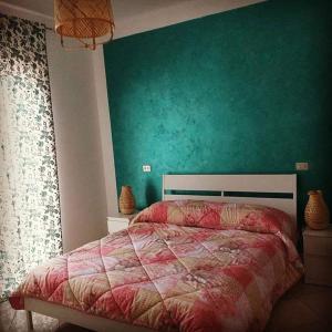 a bedroom with a bed with a green wall at I Sogni di Morfeo in Termoli