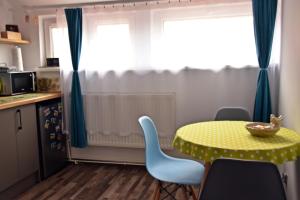 eine kleine Küche mit gelbem Tisch und Stühlen in der Unterkunft Apartament Górnicza w Kowarach in Kowary