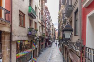 een smalle straat in een stad met gebouwen bij Precioso apartamento con Entrada autónoma en el Casco Viejo in Bilbao