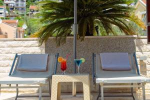 dwa krzesła i stół z drinkiem w obiekcie Apart Hotel Sun Village w mieście Herceg Novi
