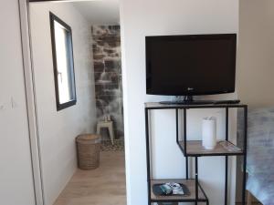 a living room with a flat screen tv on a stand at La grande Maison in Donzenac