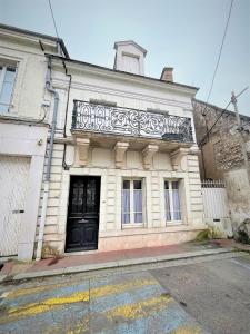 ein weißes Gebäude mit einer schwarzen Tür auf einer Straße in der Unterkunft Gîte de Ponpon, à proximité du Zoo et des Châteaux de la Loire in Selles-sur-Cher