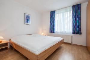 - une chambre avec un grand lit et une fenêtre dans l'établissement Sünnslag Wohnung 087, à Boltenhagen