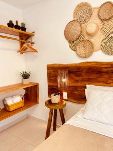 a bedroom with a bed with baskets on the wall at Suítes Jardins de Flecheiras in Flecheiras