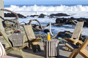 a couple of chairs sitting on a deck near the ocean at Hotel 8 al Mar in Pichilemu
