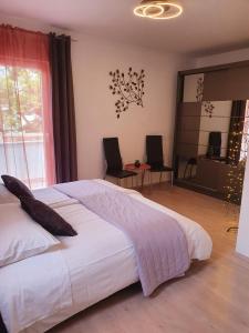 a bedroom with a large bed and a large window at Apartment Dora in Makarska
