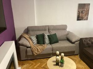 a living room with a couch with pillows and a table at Dúplex CENTRICO LA RANITA SALMANTINA in Salamanca