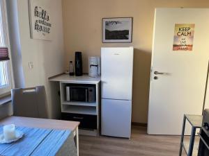 eine Küche mit einem weißen Kühlschrank und einer Mikrowelle in der Unterkunft Ferienwohnung Weins in Treis-Karden