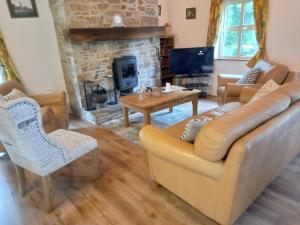 a living room with a couch and a fireplace at Cheerful Cottage in Westport