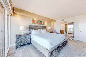 a bedroom with a bed and a desk with a lamp at Ocean Vista #1004 in South Padre Island