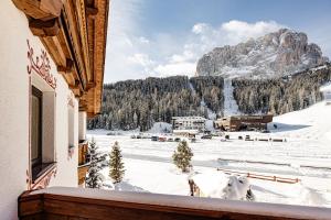 a balcony with a view of a snow covered mountain at Suites Hotel Garden in Selva di Val Gardena