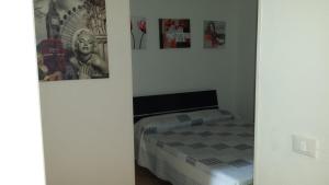 sypialnia z łóżkiem i obrazami na ścianie w obiekcie Appartamento Colletta w mieście Ventimiglia