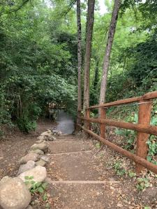 a wooden fence and a path in the woods at River Tribe Experience Camp in Laino Borgo