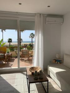 a bedroom with a bed and a view of a patio at BEACH FRONT ATICO WIFI in Tarifa