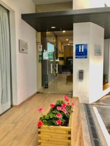 a wooden planter with red flowers in a lobby at Hotel Mencia Subbética in Doña Mencía