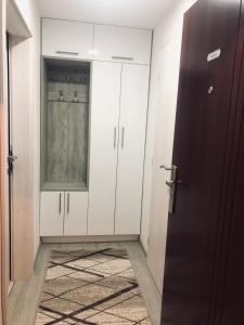 Cette chambre comprend des armoires blanches, une porte et un tapis. dans l'établissement Mini apartman Smile, à Travnik