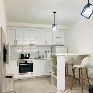 a white kitchen with white cabinets and a counter at Mini apartman Smile in Travnik
