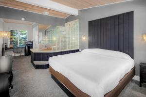 a bedroom with a large bed and a bathroom at The Inn at Boatworks, Lake Tahoe in Tahoe City