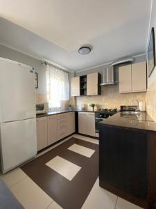 a kitchen with white appliances and a black counter top at Apartament - Leśna Apart in Hel