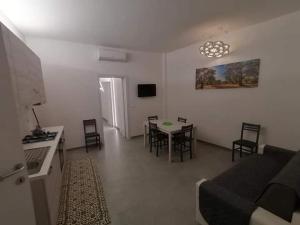 a living room with a couch and a table and chairs at Dimora Felline in Giurdignano